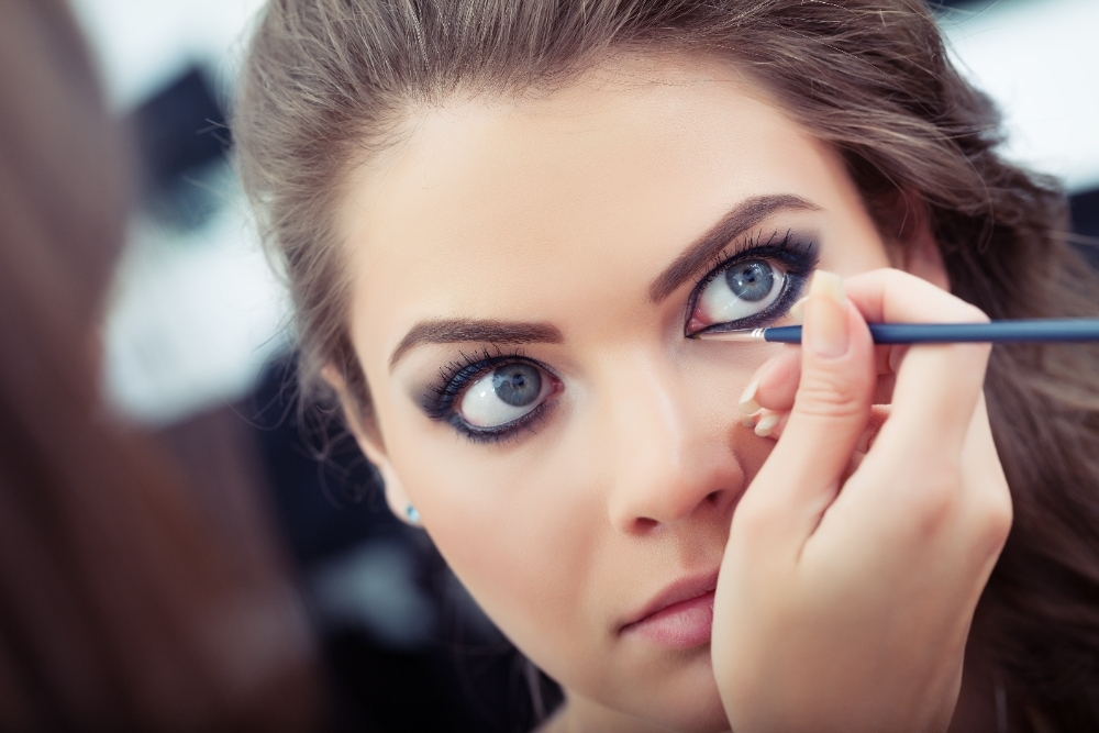 Makeup artist applying liquid eyeliner with brush close up