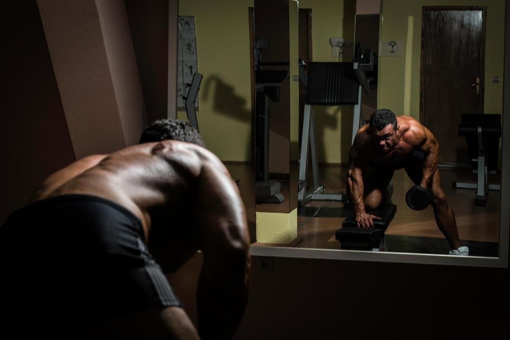 Male bodybuilder doing heavy weight exercise for back